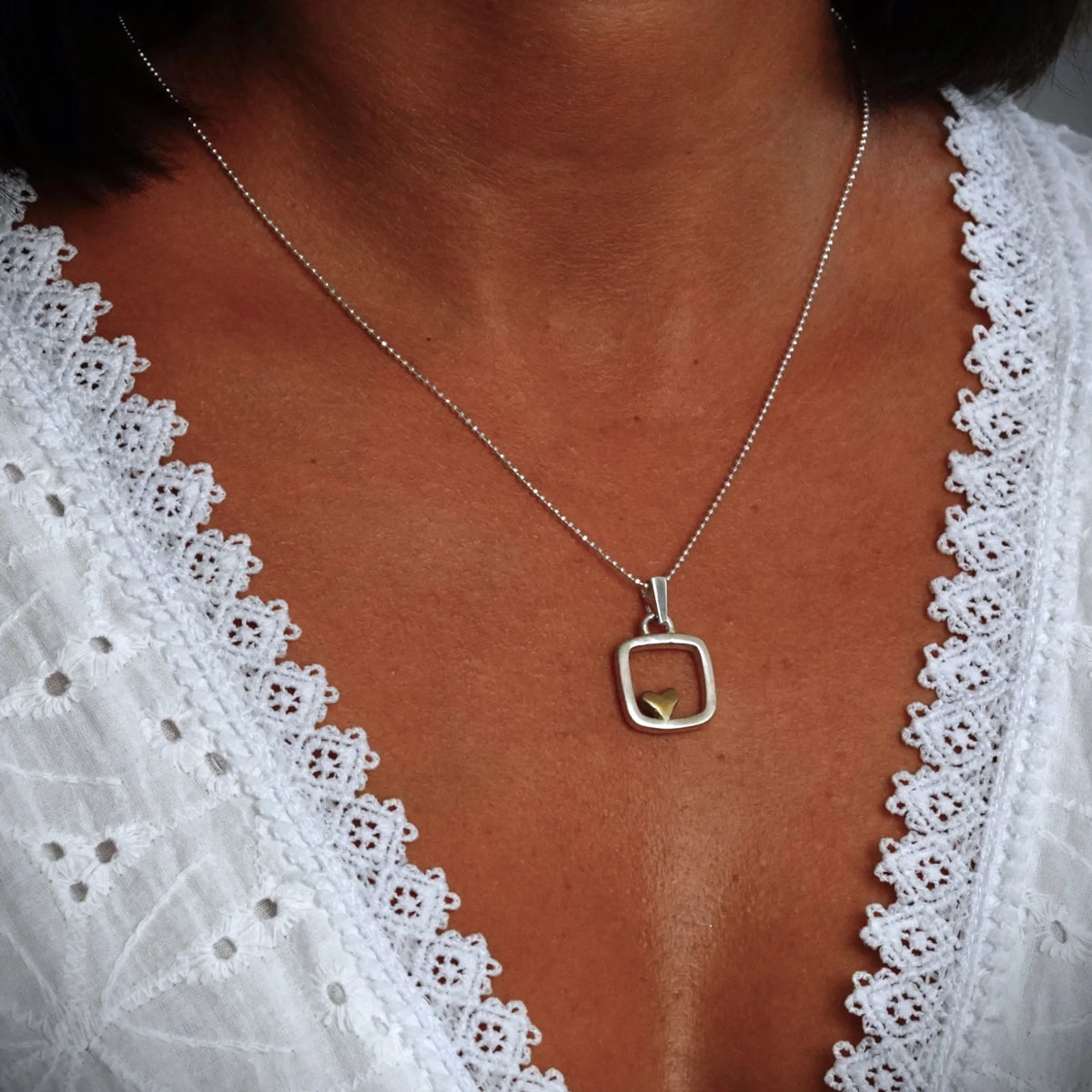 „Herz im Quadrat“ – handgefertigter Anhänger aus 925er Silber mit goldfarbenen Akzenten, Talisman für Liebe und Ausgeglichenheit, Skulpturenschmuck im Boho- und rustikalen Stil | Art Diva
