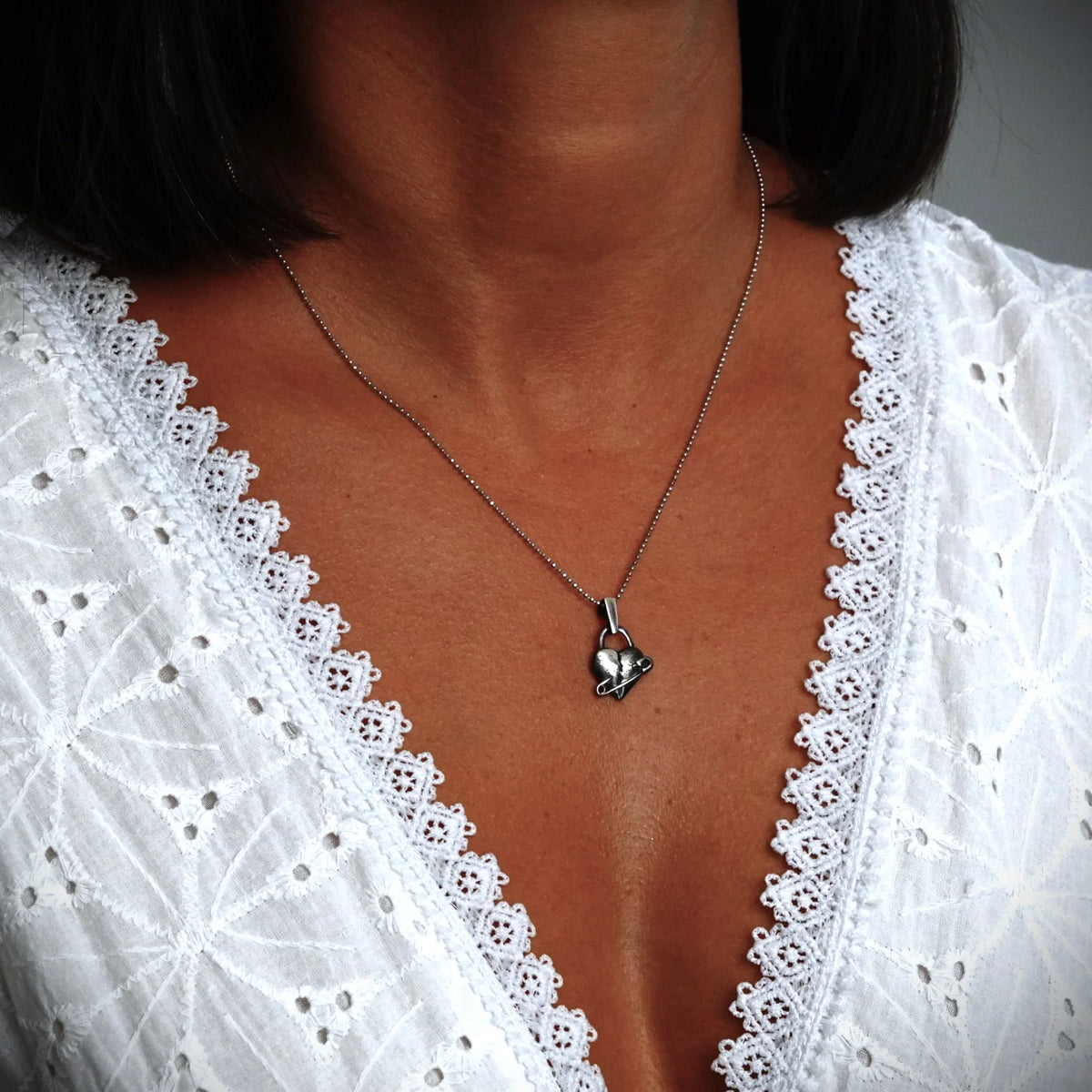 „Geflicktes Herz“-Anhänger aus 925er Silber mit Sicherheitsnadel – Symbol für erlebten Schmerz und bleibende emotionale Spuren, oxidierter Skulpturenschmuck im Boho- und rustikalen Stil | Art Diva