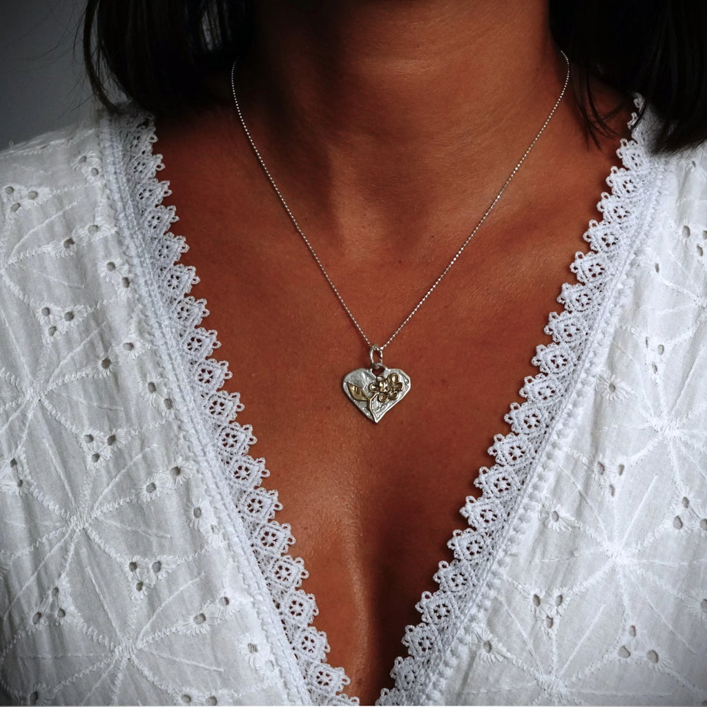 Talisman für Liebe und Geborgenheit – handgefertigter Herzanhänger aus 925er Silber mit Blume und goldfarbenen Akzenten im Boho- und rustikalen Stil | Art Diva