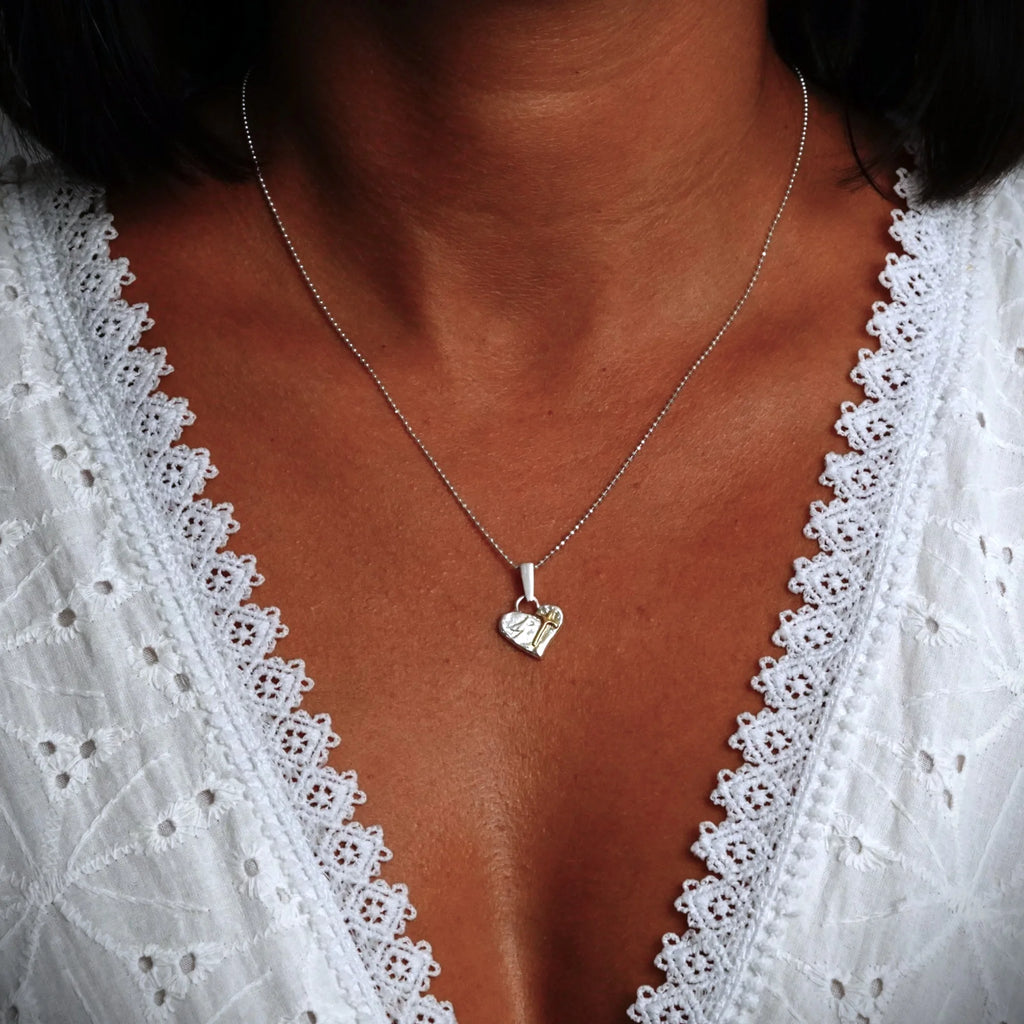 „Glaube an die Liebe“-Miniaturanhänger mit Herz und Kreuz aus 925er Silber mit vergoldeten Akzenten – handgefertigtes Symbol spiritueller Liebe, rustikaler Skulpturenschmuck aus der Kollektion „Glanz“ | Art Diva