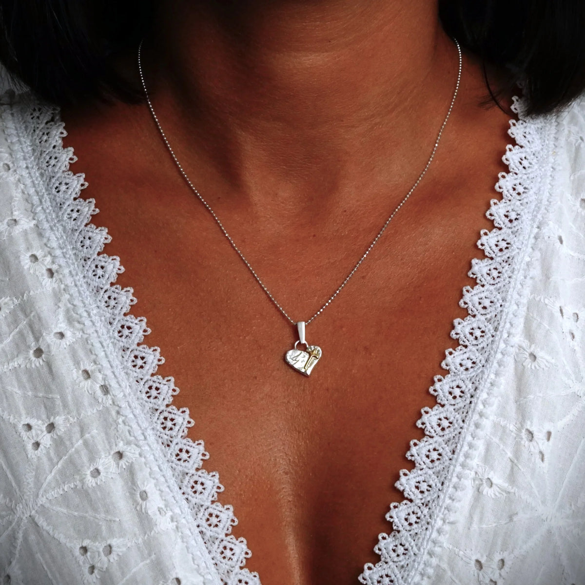 „Glaube an die Liebe“-Miniaturanhänger mit Herz und Kreuz aus 925er Silber mit vergoldeten Akzenten – handgefertigtes Symbol spiritueller Liebe, rustikaler Skulpturenschmuck aus der Kollektion „Glanz“ | Art Diva
