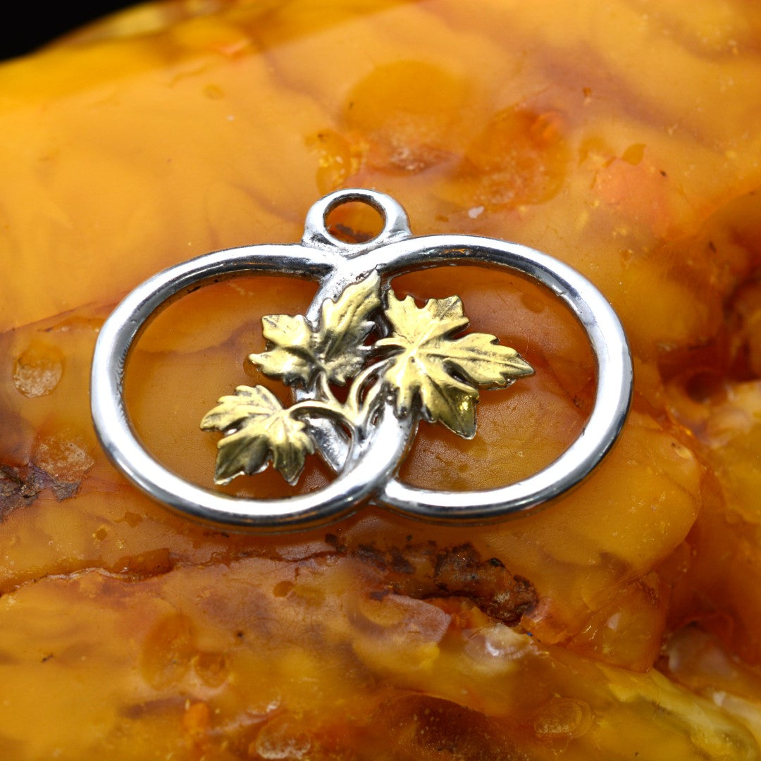 „Zwei Ringe mit Weinblättern“-Anhänger aus 925er Silber mit goldenen Akzenten – handgefertigter Talisman für Verbundenheit und Wachstum, skulpturaler Schmuck im Boho-Rustik-Stil | Art Diva