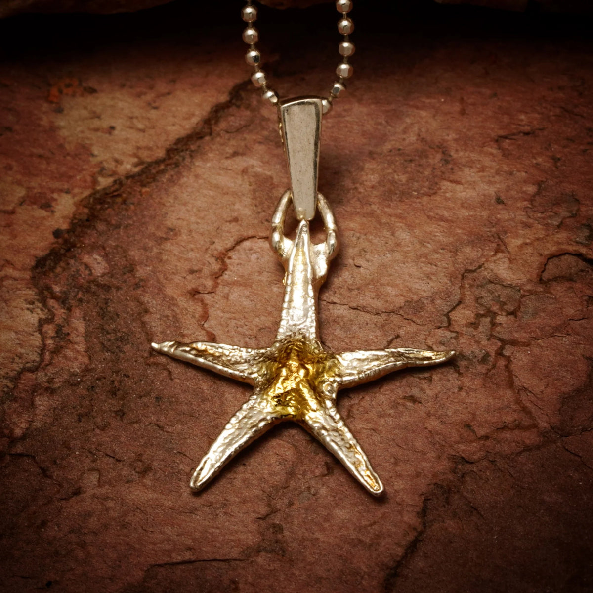„Seestern“ – Anhänger aus 925er Silber mit goldfarbenen Akzenten, Talisman für Glück und Gelassenheit, Skulpturenschmuck im Boho- und rustikalen Stil | Art Diva