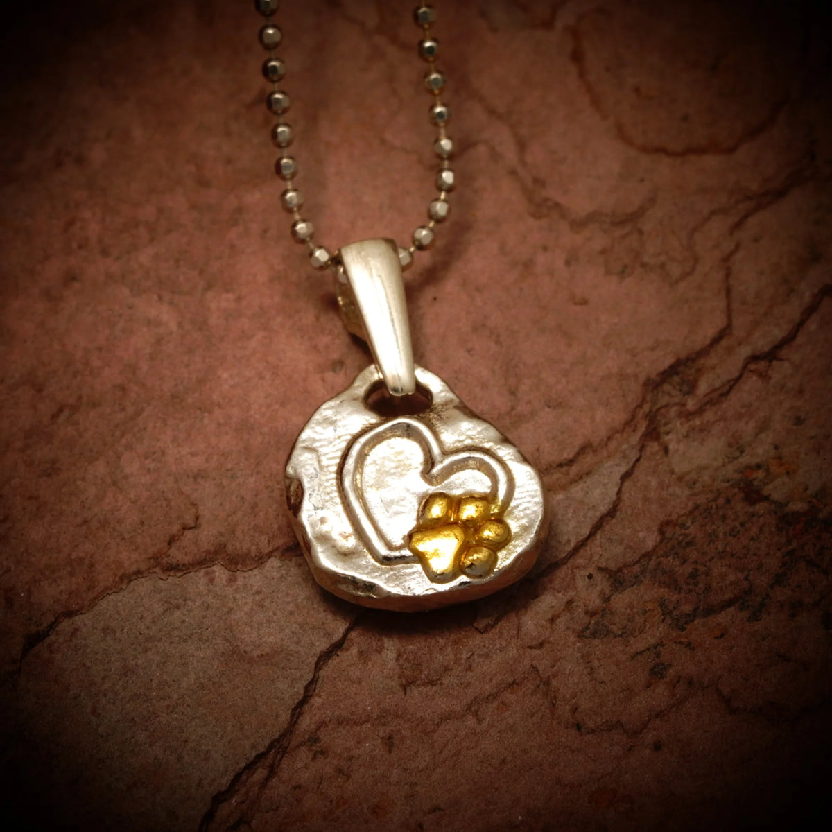 „Pfote im Herzen“-Anhänger aus 925er Silber mit goldfarbenen Akzenten – Talisman für die Liebe zu Tieren, Skulpturenschmuck im Boho- und rustikalen Stil | Art Diva