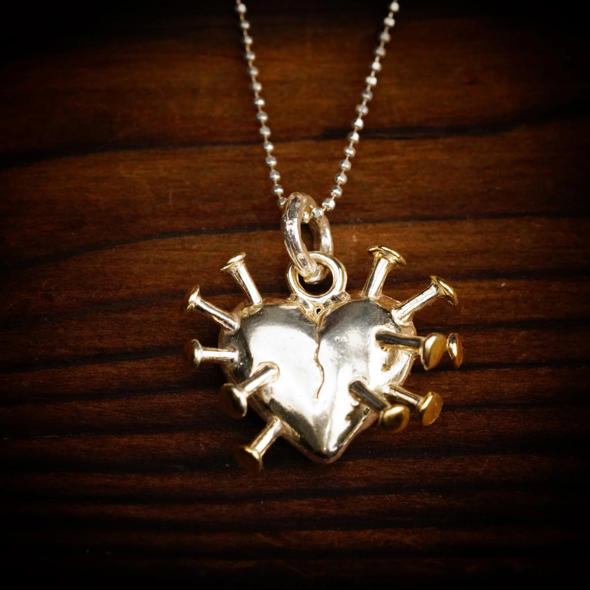„Herz mit Nägeln“-Anhänger aus 925er Silber mit goldfarbenen Akzenten – Symbol für Schmerz, Heilung und innere Stärke, Skulpturenschmuck im Boho- und rustikalen Stil | Art Diva