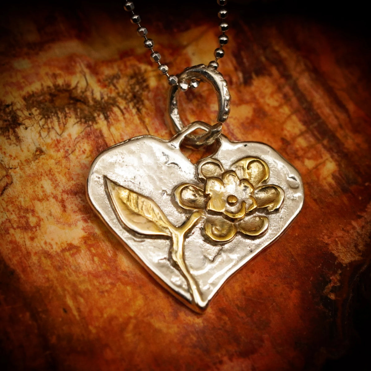 Talisman für Liebe und Geborgenheit – handgefertigter Herzanhänger aus 925er Silber mit Blume und goldfarbenen Akzenten im Boho- und rustikalen Stil | Art Diva