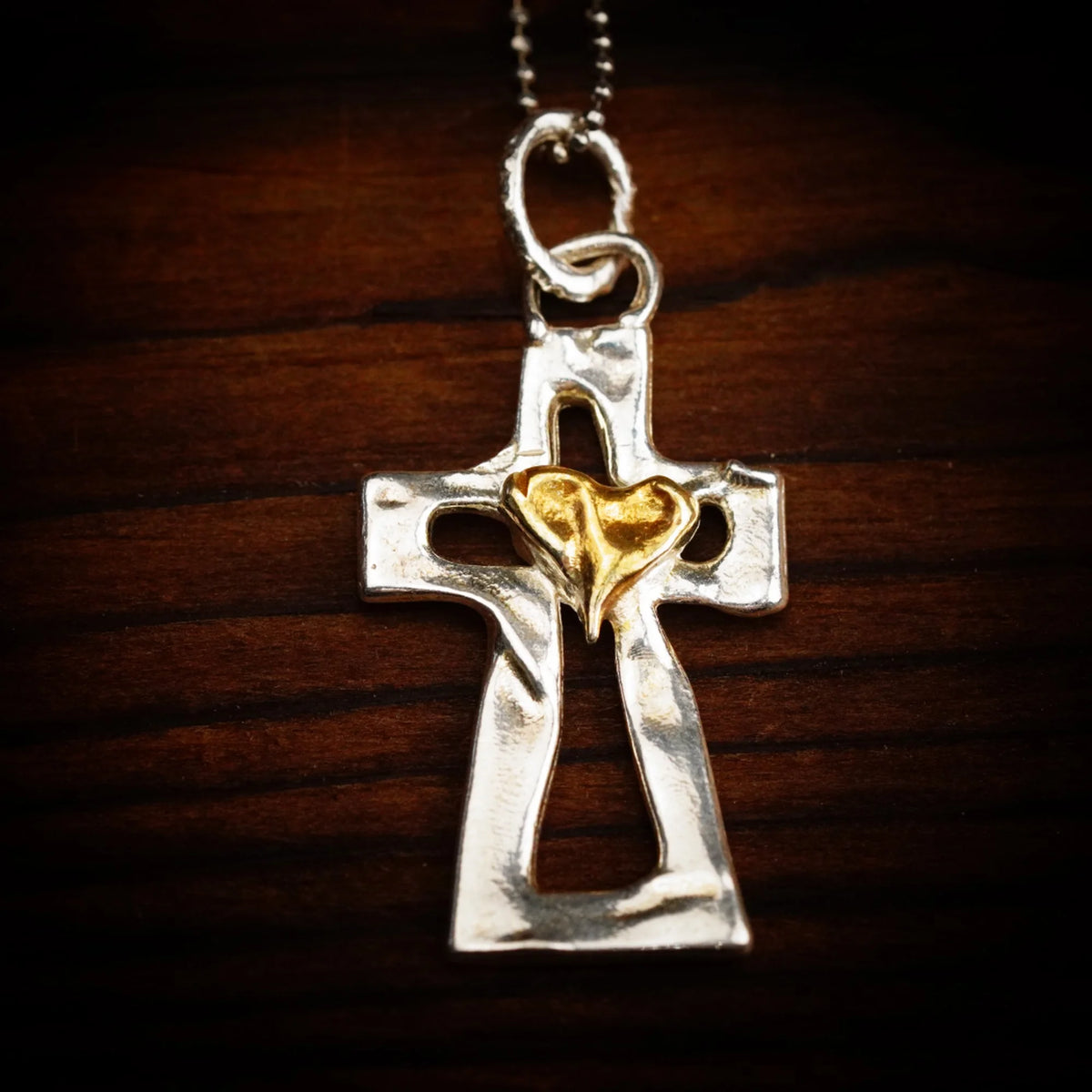 Kreuz-Anhänger mit Herz aus 925er Silber und goldfarbenen Akzenten – Skulpturenschmuck als Symbol für Glauben und Liebe | Art Diva
