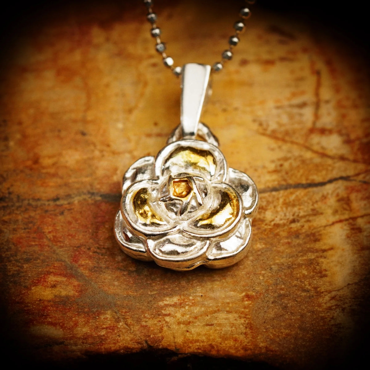 „Kamelie“ – handgefertigter Anhänger aus 925er Silber mit goldfarbenen Akzenten, Talisman für Weiblichkeit, innere Stärke und Schönheit, Skulpturenschmuck im Boho- und rustikalen Stil | Art Diva