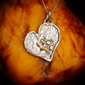 Herz-Anhänger mit Pfote aus 925er Silber und goldfarbenen Akzenten – Talisman für Treue und Tierliebe, handgefertigter Skulpturenschmuck im Boho- und rustikalen Stil, Kollektion „Glanz“ | Art Diva