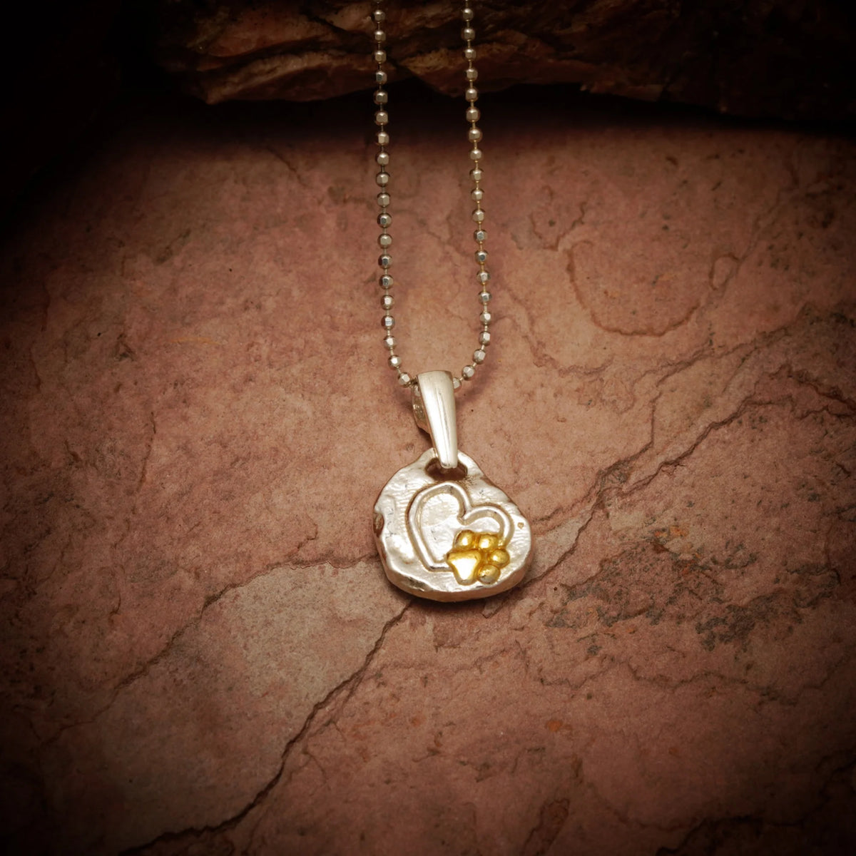 „Pfote im Herzen“-Anhänger aus 925er Silber mit goldfarbenen Akzenten – Talisman für die Liebe zu Tieren, Skulpturenschmuck im Boho- und rustikalen Stil | Art Diva