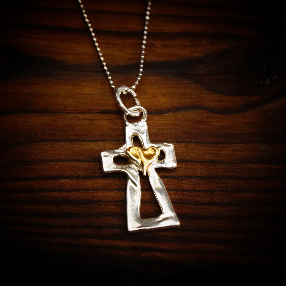 Kreuz-Anhänger mit Herz aus 925er Silber und goldfarbenen Akzenten – Skulpturenschmuck als Symbol für Glauben und Liebe | Art Diva