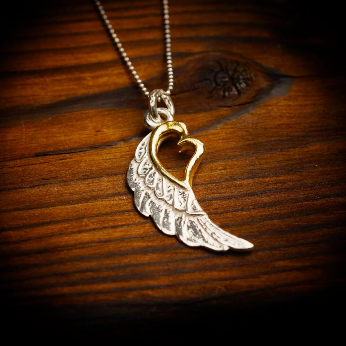 „Flügel mit Herz“-Anhänger aus 925er Silber mit goldfarbenen Akzenten – Talisman für Liebe und Schutz, Skulpturenschmuck im Boho-Stil | Art Diva