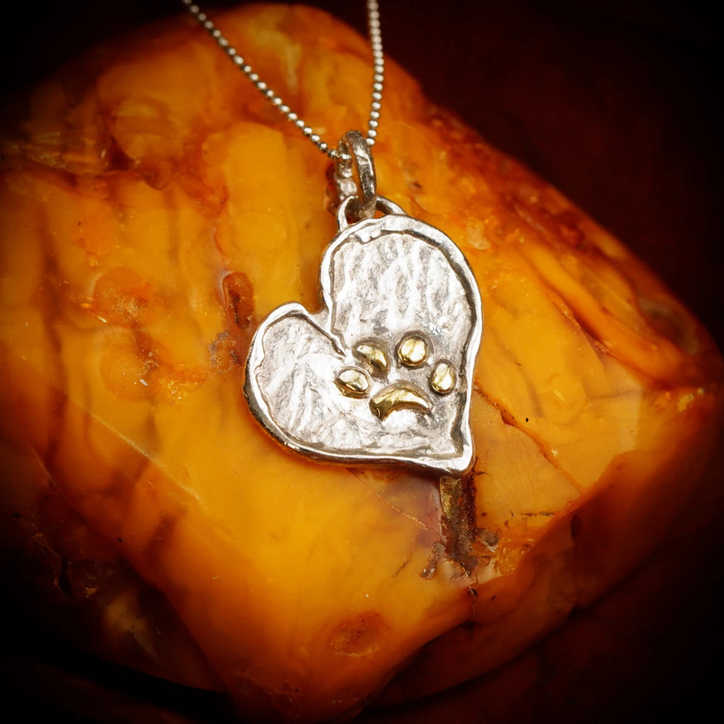 Herz-Anhänger mit Pfote aus 925er Silber und goldfarbenen Akzenten – Talisman für Treue und Tierliebe, handgefertigter Skulpturenschmuck im Boho- und rustikalen Stil, Kollektion „Glanz“ | Art Diva
