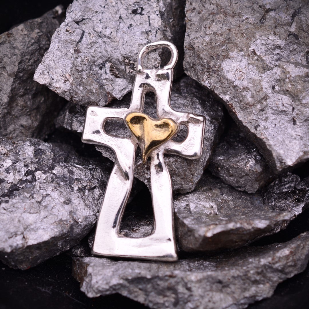 Kreuz-Anhänger mit Herz aus 925er Silber und goldfarbenen Akzenten – Skulpturenschmuck als Symbol für Glauben und Liebe | Art Diva