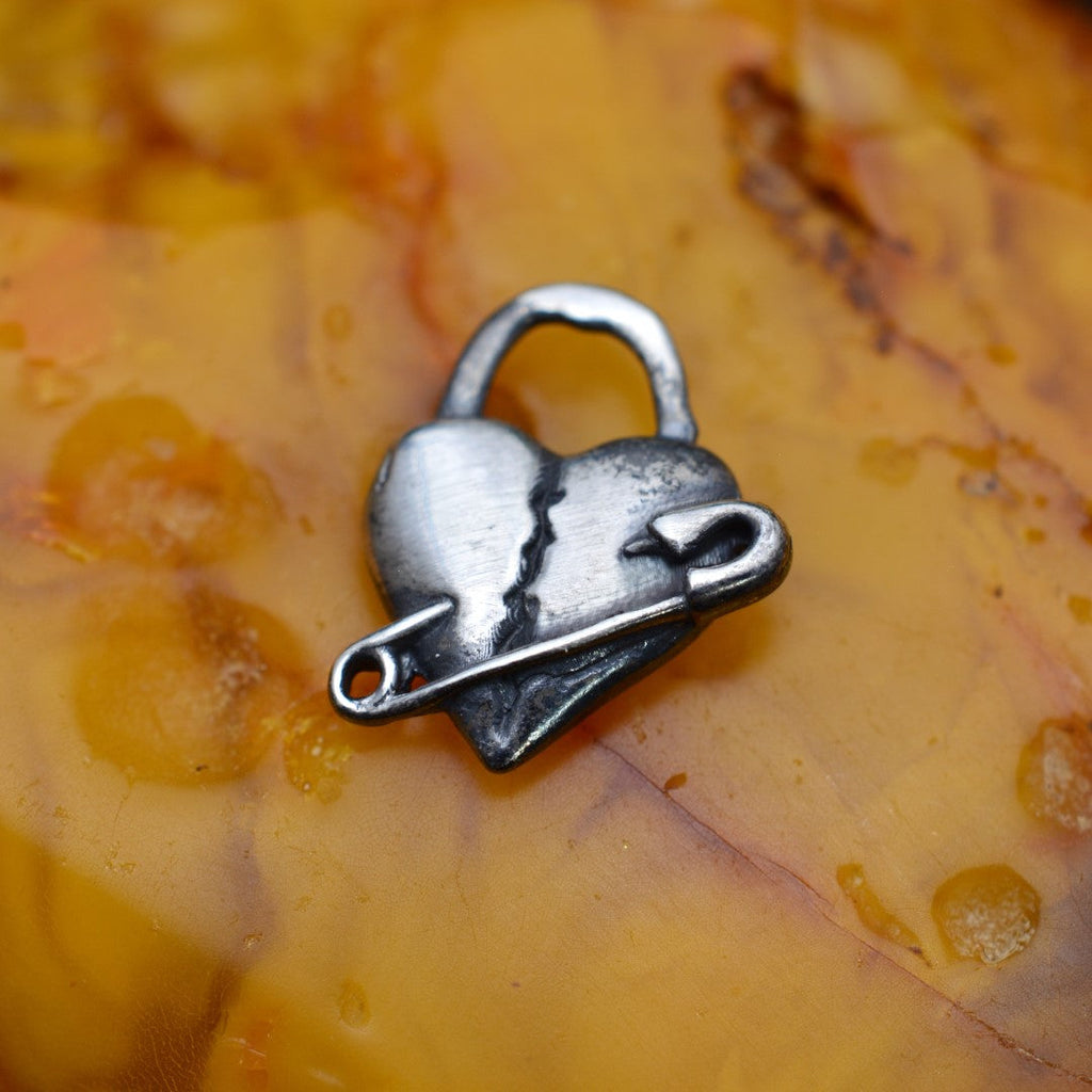 „Geflicktes Herz“-Anhänger aus 925er Silber mit Sicherheitsnadel – Symbol für erlebten Schmerz und bleibende emotionale Spuren, oxidierter Skulpturenschmuck im Boho- und rustikalen Stil | Art Diva