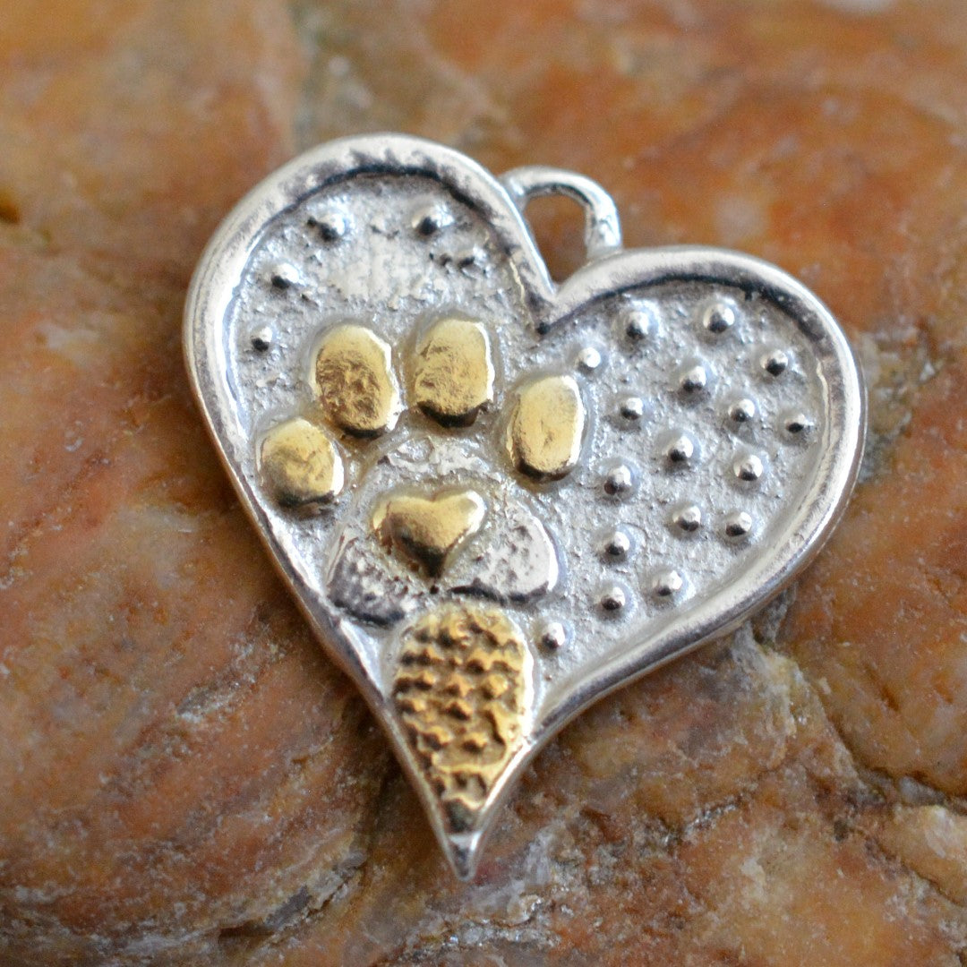 „Glanz“ – Herz-Anhänger mit Pfote aus 925er Silber und goldfarbenen Akzenten, Talisman für Tierliebe, handgefertigter Skulpturenschmuck im Boho- und rustikalen Stil | Art Diva