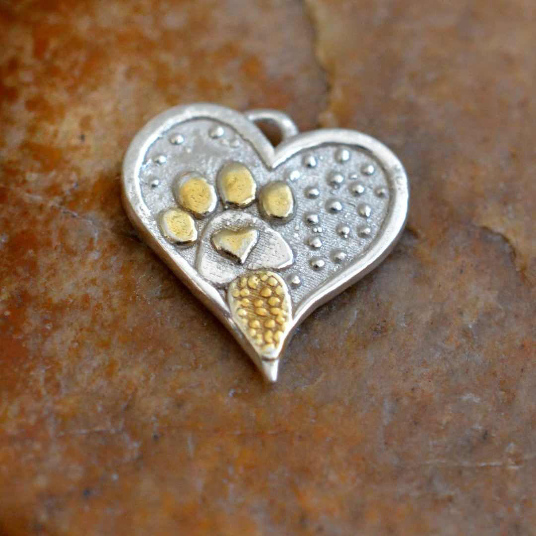 „Glanz“ – Herz-Anhänger mit Pfote aus 925er Silber und goldfarbenen Akzenten, Talisman für Tierliebe, handgefertigter Skulpturenschmuck im Boho- und rustikalen Stil | Art Diva