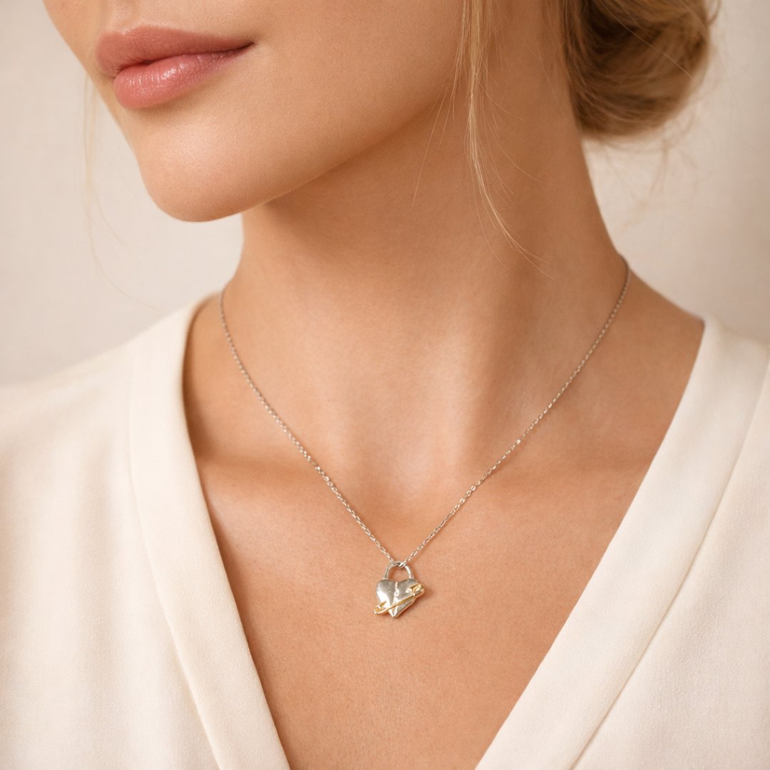 „Verletztes Herz“-Anhänger aus 925er Silber mit goldfarbenem Sicherheitsnadel-Akzent – Symbol für erlebten Schmerz und bleibende emotionale Spuren, Skulpturenschmuck im Boho- und rustikalen Stil | Art Diva