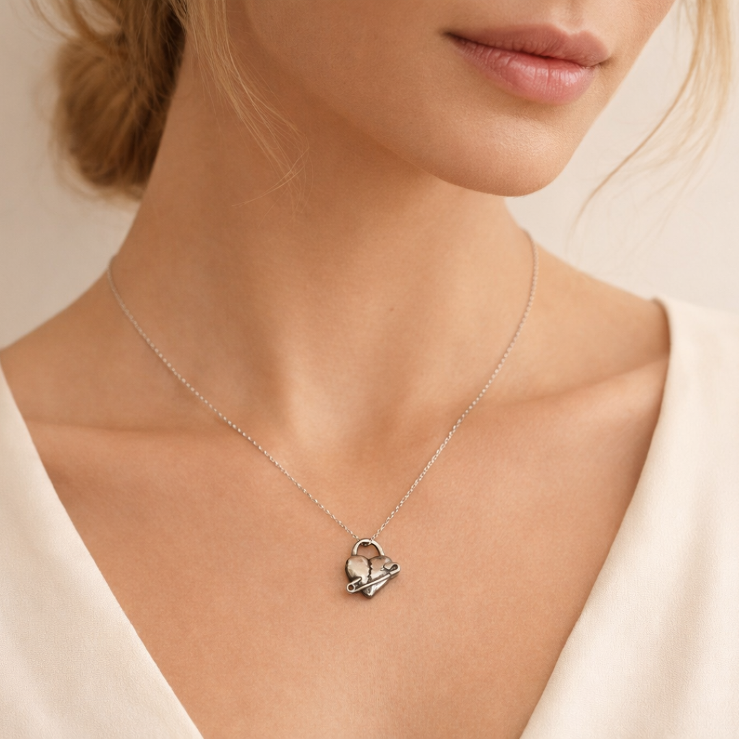 „Geflicktes Herz“-Anhänger aus 925er Silber mit Sicherheitsnadel – Symbol für erlebten Schmerz und bleibende emotionale Spuren, oxidierter Skulpturenschmuck im Boho- und rustikalen Stil | Art Diva