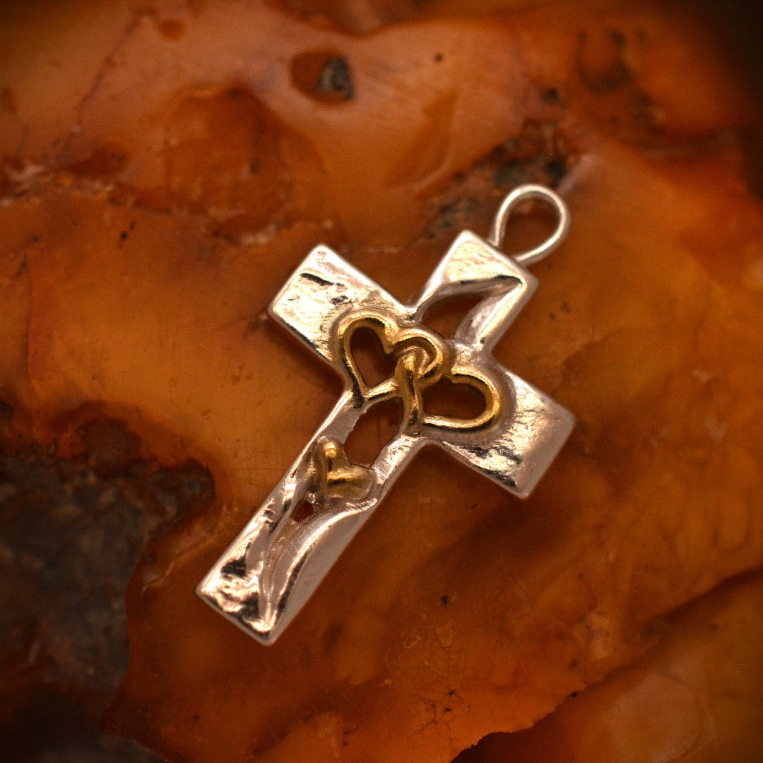 „Dreifaches Herz im Kreuz“-Anhänger aus 925er Silber mit goldfarbenen Akzenten – Symbol für Liebe, Glauben und Schutz, Skulpturenschmuck im Boho- und rustikalen Stil | Art Diva