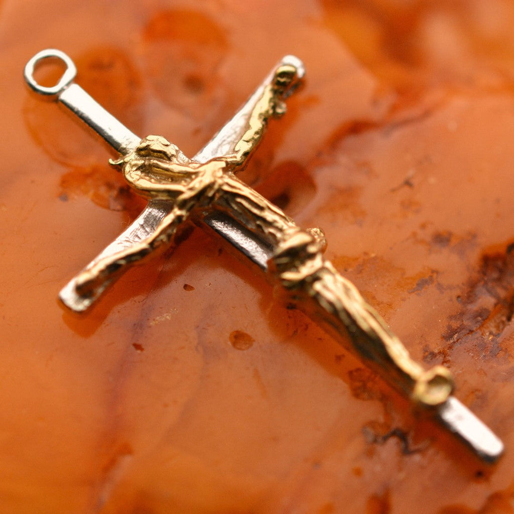 Kruzifix-Anhänger mit kunstvoll geschwungener Christusfigur aus 925er Silber und goldfarbenen Akzenten – handgefertigtes Symbol für Glauben und Schutz im Boho- und rustikalen Stil | Art Diva