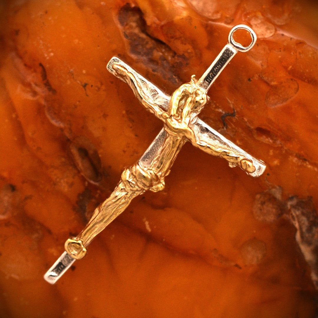 Kruzifix-Anhänger mit kunstvoll geschwungener Christusfigur aus 925er Silber und goldfarbenen Akzenten – handgefertigtes Symbol für Glauben und Schutz im Boho- und rustikalen Stil | Art Diva