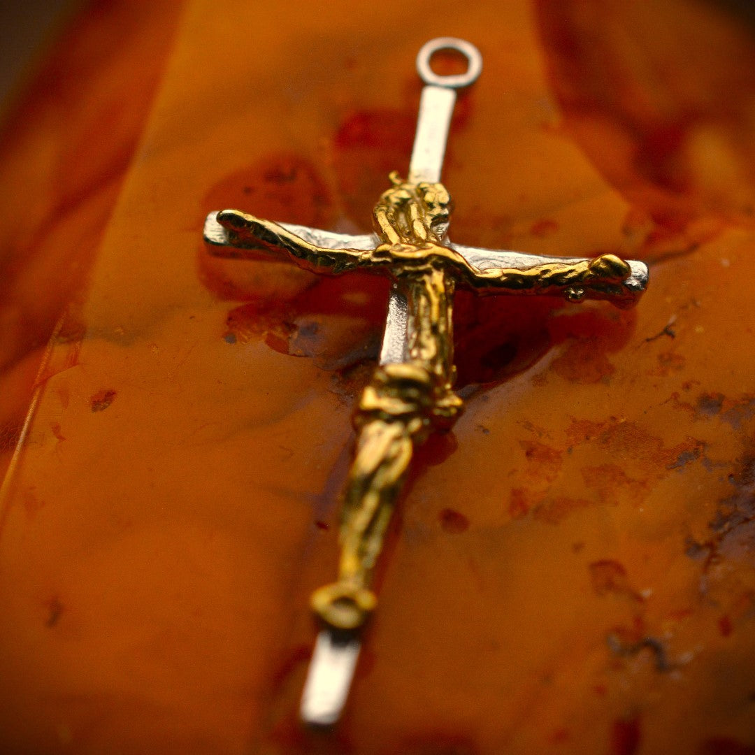 Kruzifix-Anhänger mit kunstvoll geschwungener Christusfigur aus 925er Silber und goldfarbenen Akzenten – handgefertigtes Symbol für Glauben und Schutz im Boho- und rustikalen Stil | Art Diva
