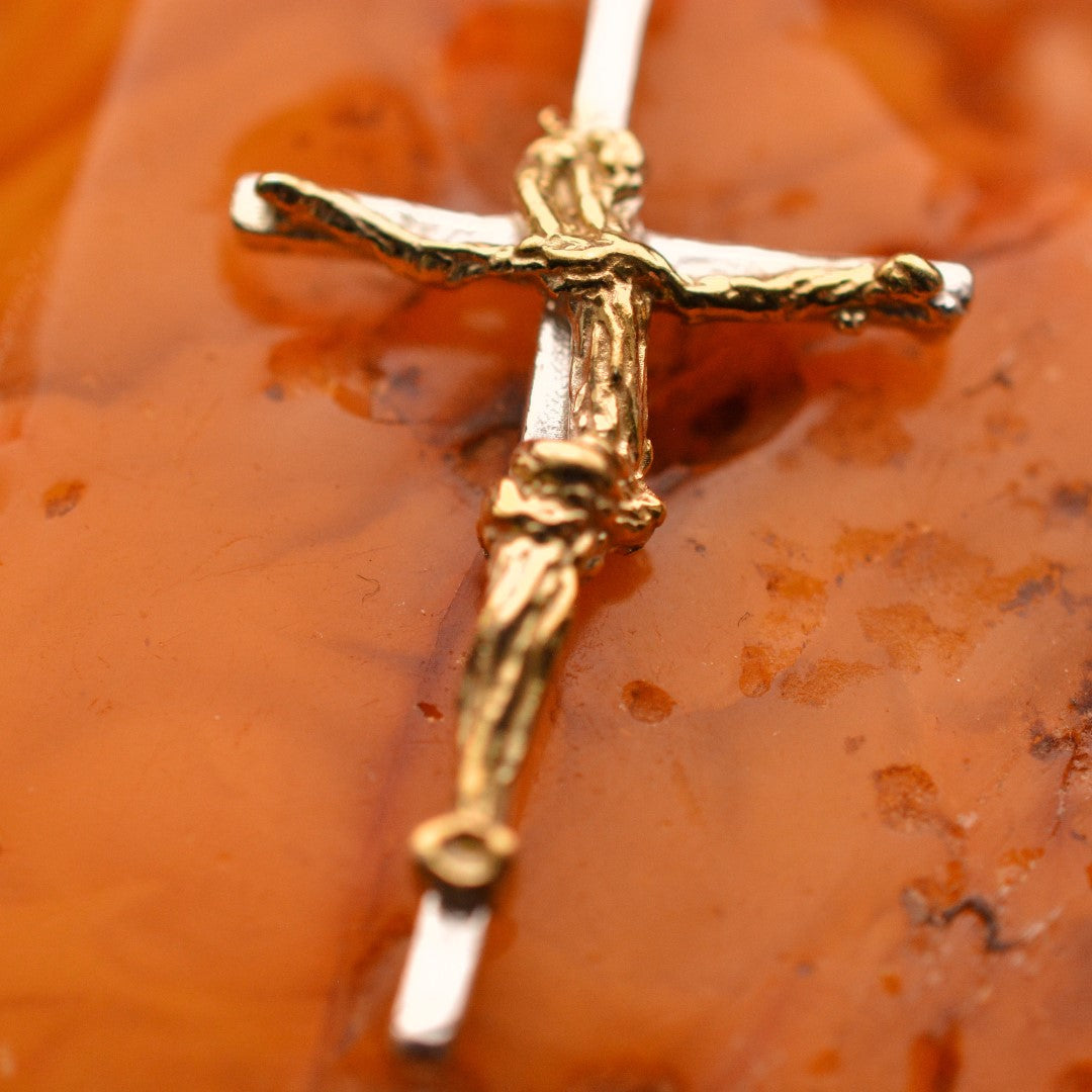 Kruzifix-Anhänger mit kunstvoll geschwungener Christusfigur aus 925er Silber und goldfarbenen Akzenten – handgefertigtes Symbol für Glauben und Schutz im Boho- und rustikalen Stil | Art Diva